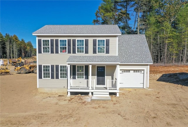 colonial inspired home with a garage and covered porch