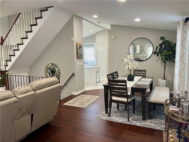 dining room with hardwood / wood-style flooring, lofted ceiling, and sink