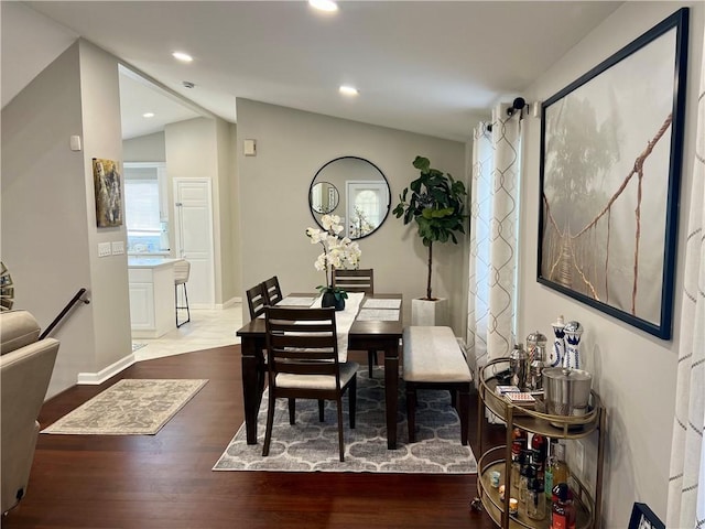 dining room featuring wood-type flooring and vaulted ceiling