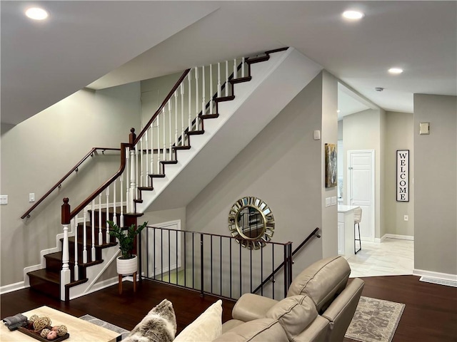 stairway with hardwood / wood-style flooring and lofted ceiling