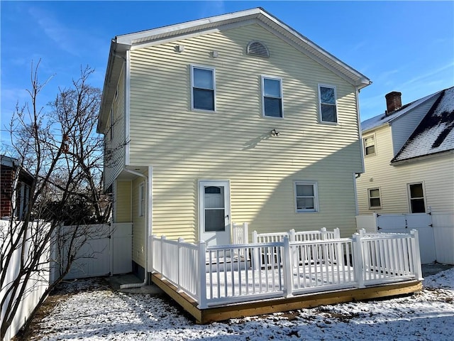 snow covered house with a deck