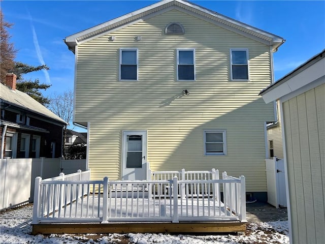 snow covered house featuring a deck