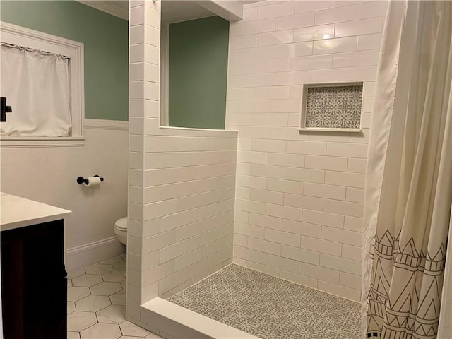 bathroom with tile patterned flooring, vanity, toilet, and walk in shower