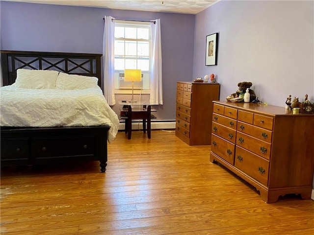 bedroom featuring light wood-type flooring, baseboard heating, and cooling unit