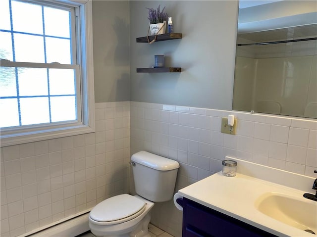 bathroom featuring a wealth of natural light, toilet, baseboard heating, and tile walls