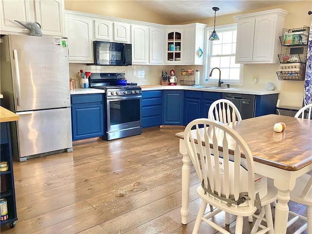 kitchen with tasteful backsplash, blue cabinets, and black appliances