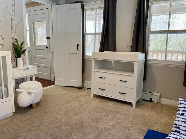 carpeted bedroom with a baseboard heating unit and multiple windows