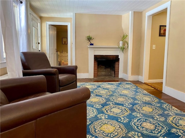 living room with hardwood / wood-style floors and a brick fireplace