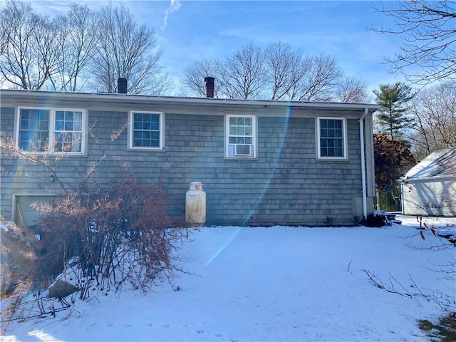 view of snow covered back of property