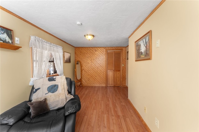 interior space with crown molding, light hardwood / wood-style floors, and a textured ceiling