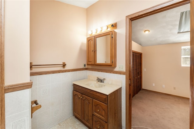 bathroom with vanity and tile walls