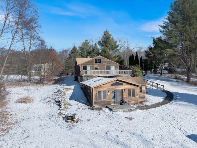 snow covered property with a balcony