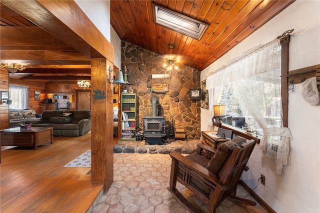 living room with a wood stove, lofted ceiling with skylight, and wood ceiling