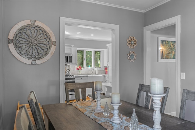 dining room featuring ornamental molding and sink