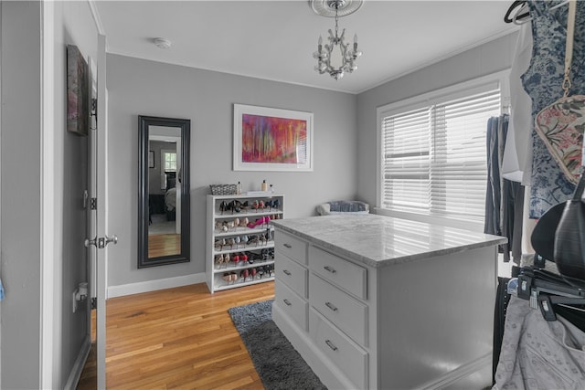 spacious closet featuring a chandelier and light hardwood / wood-style floors