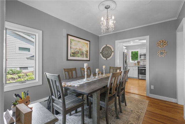 dining room featuring an inviting chandelier, wood-type flooring, and ornamental molding