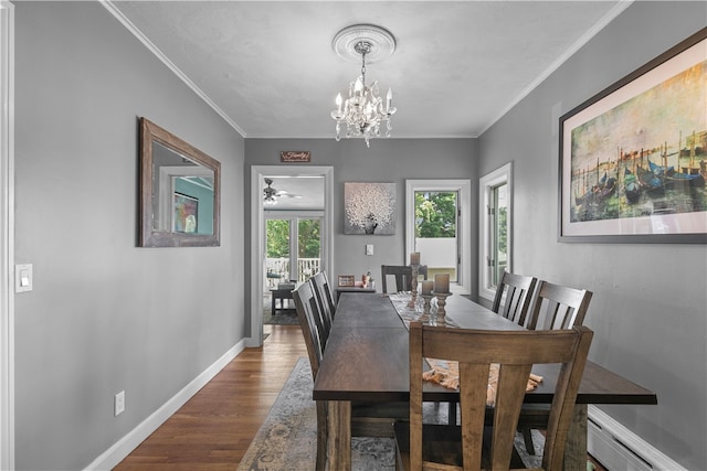 dining space with dark hardwood / wood-style flooring, a baseboard radiator, an inviting chandelier, and crown molding