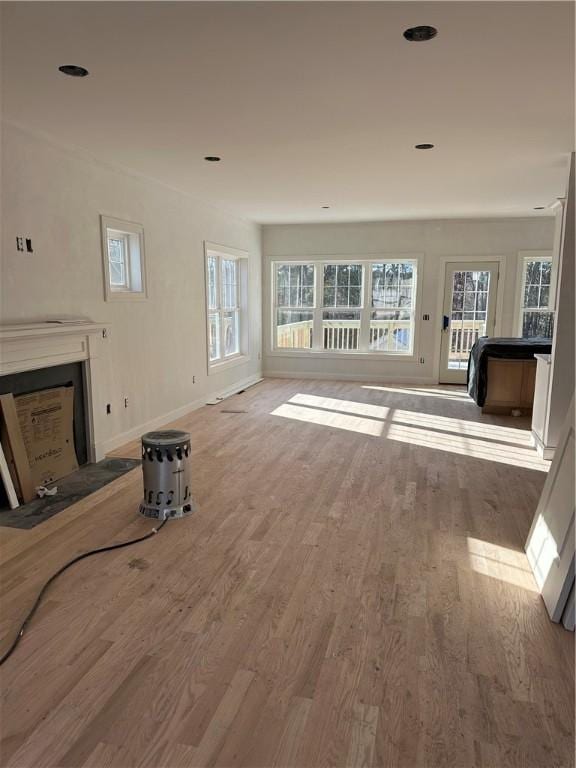 unfurnished living room with light hardwood / wood-style floors and plenty of natural light