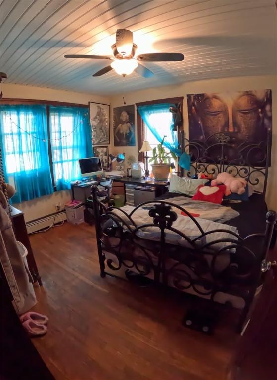 bedroom with ceiling fan, a baseboard radiator, hardwood / wood-style floors, and wooden ceiling