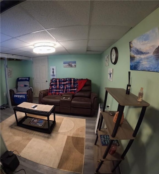 living room with a paneled ceiling and hardwood / wood-style floors