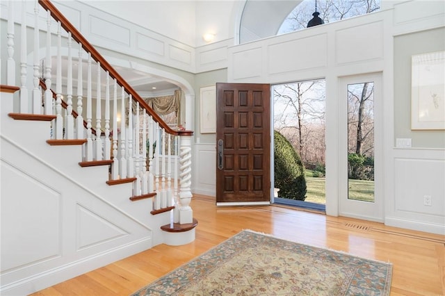 entrance foyer featuring a towering ceiling and light hardwood / wood-style flooring