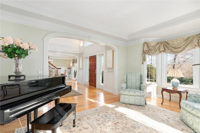 living area featuring crown molding and light hardwood / wood-style floors