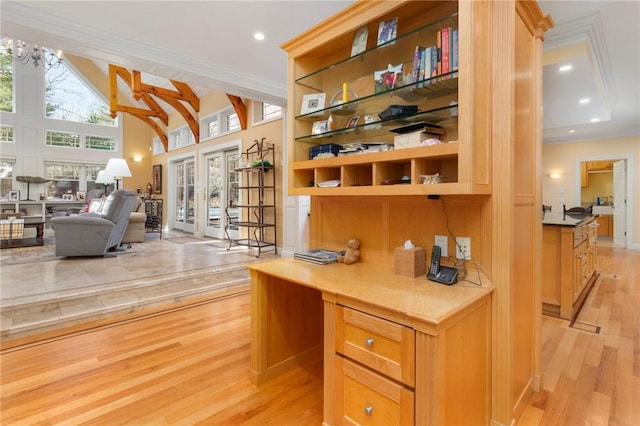 office with ornamental molding, built in shelves, high vaulted ceiling, and light hardwood / wood-style flooring