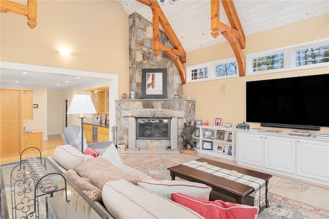 living room featuring beamed ceiling, a stone fireplace, high vaulted ceiling, and wooden ceiling