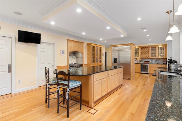 kitchen with pendant lighting, sink, crown molding, wine cooler, and stainless steel built in fridge