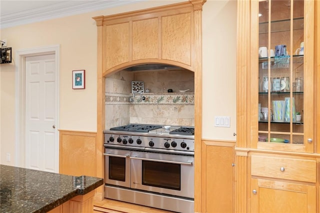 kitchen featuring crown molding, double oven range, light brown cabinetry, decorative backsplash, and dark stone counters