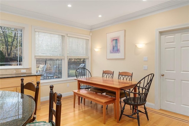 dining room with crown molding and light wood-type flooring