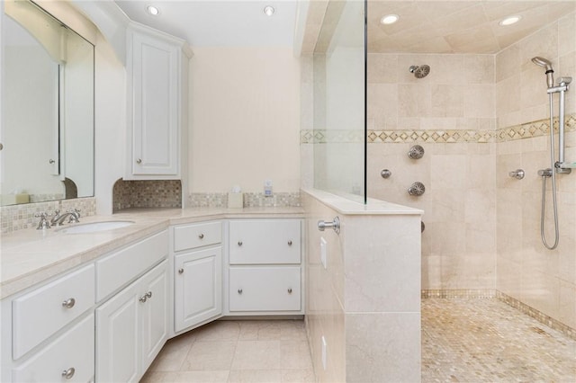 bathroom with vanity, tasteful backsplash, and a tile shower