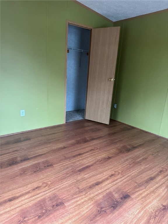 unfurnished bedroom with a closet, hardwood / wood-style floors, and a textured ceiling