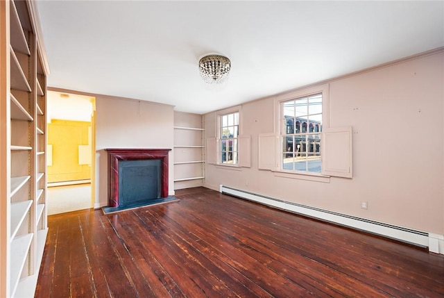 unfurnished living room featuring built in features, dark wood-type flooring, a notable chandelier, and a baseboard heating unit