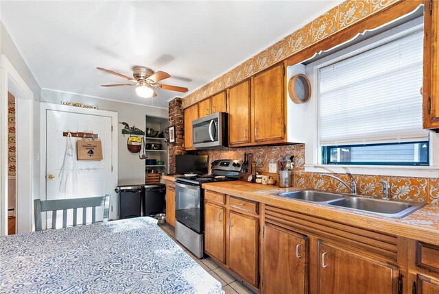 kitchen featuring ceiling fan, sink, appliances with stainless steel finishes, and tasteful backsplash