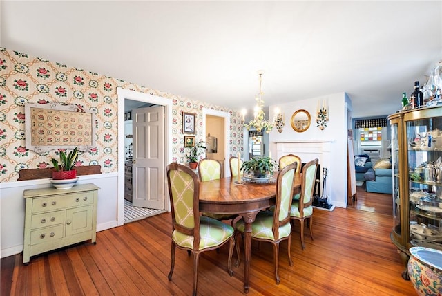 dining area with wood-type flooring and a chandelier