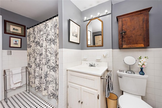 bathroom featuring curtained shower, tile patterned flooring, toilet, vanity, and tile walls