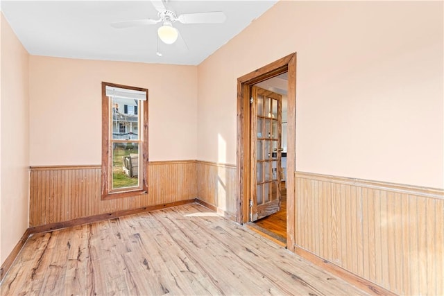 empty room featuring ceiling fan, light hardwood / wood-style floors, and lofted ceiling