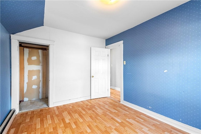 unfurnished bedroom featuring a baseboard radiator and hardwood / wood-style flooring