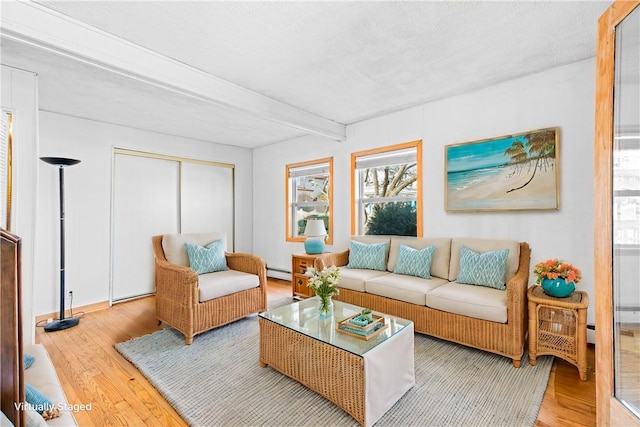 living room featuring beamed ceiling, wood-type flooring, and baseboard heating