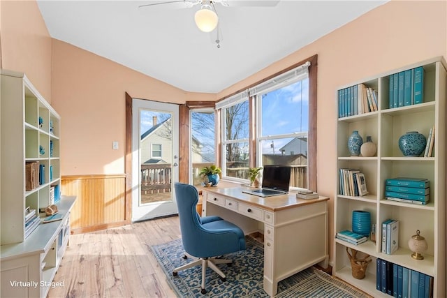 office space with light hardwood / wood-style flooring, ceiling fan, a healthy amount of sunlight, and wood walls