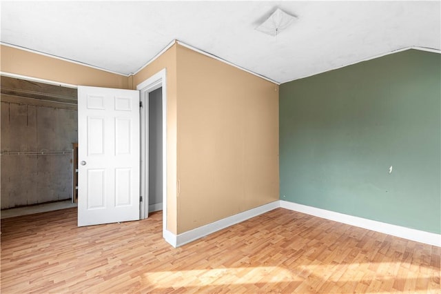 unfurnished bedroom featuring light hardwood / wood-style floors and lofted ceiling