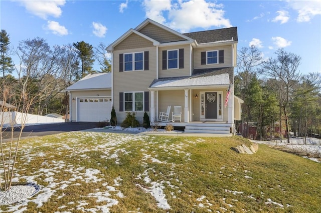 view of front of home with a yard, covered porch, and a garage