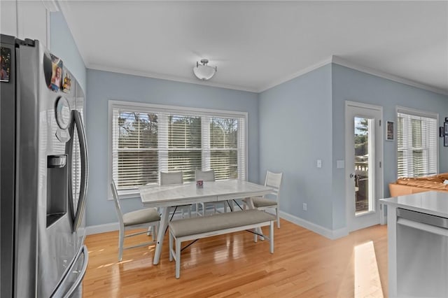 dining room featuring light hardwood / wood-style floors, a healthy amount of sunlight, and ornamental molding