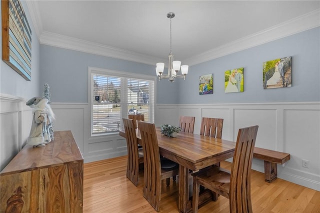 dining room with crown molding, a chandelier, and light wood-type flooring