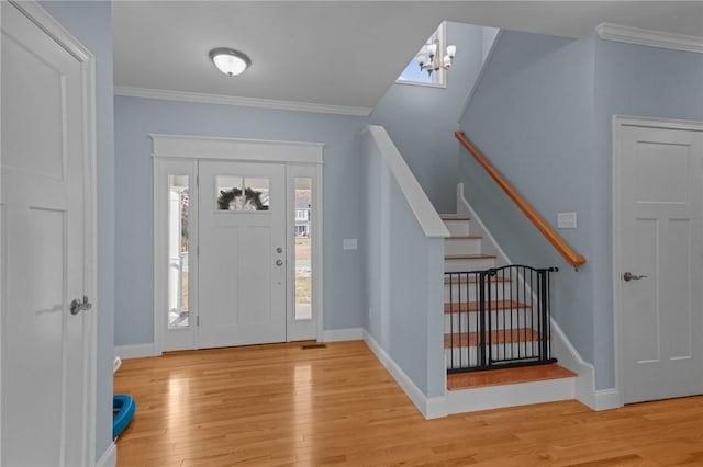 entrance foyer featuring a chandelier, light hardwood / wood-style flooring, and crown molding