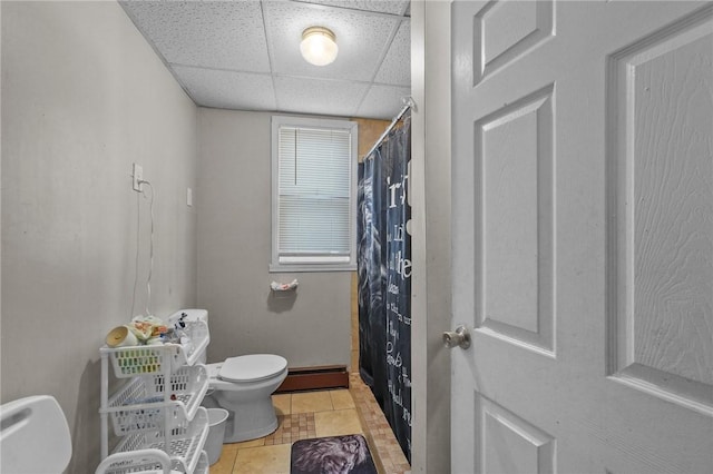 bathroom featuring a drop ceiling, a shower with curtain, a baseboard radiator, tile patterned flooring, and toilet