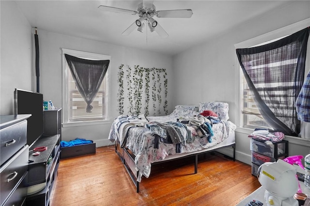 bedroom with multiple windows, ceiling fan, and light wood-type flooring