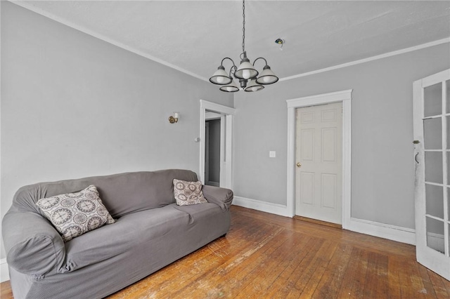 living room featuring a chandelier, wood-type flooring, and crown molding