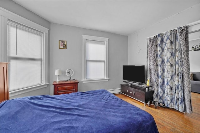 bedroom featuring wood-type flooring and baseboard heating